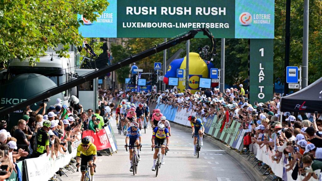 Škoda Tour de Luxembourg 2024 : des cyclistes sont visibles ainsi qu'une caméra en hauteur capturant les moments clés de la course.